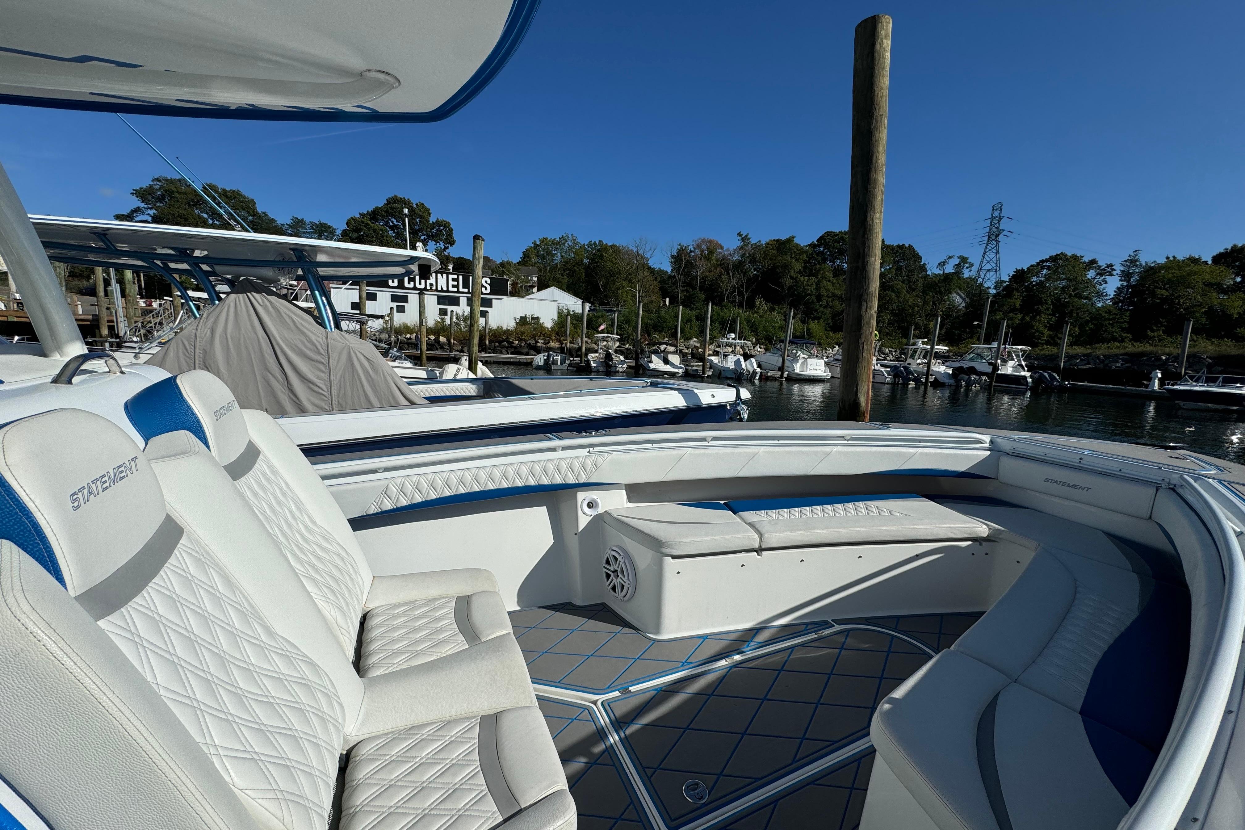 2016 Statement 350 Open boat with white seating, docked at a marina under clear blue skies.