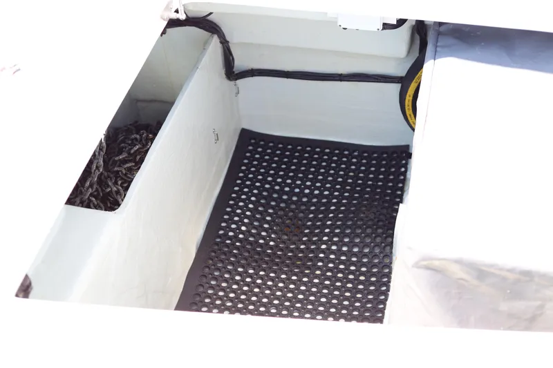 Why Knot Yacht Photos Pics Open compartment in a 2020 Robertson Leopard boat, featuring a black perforated mat.