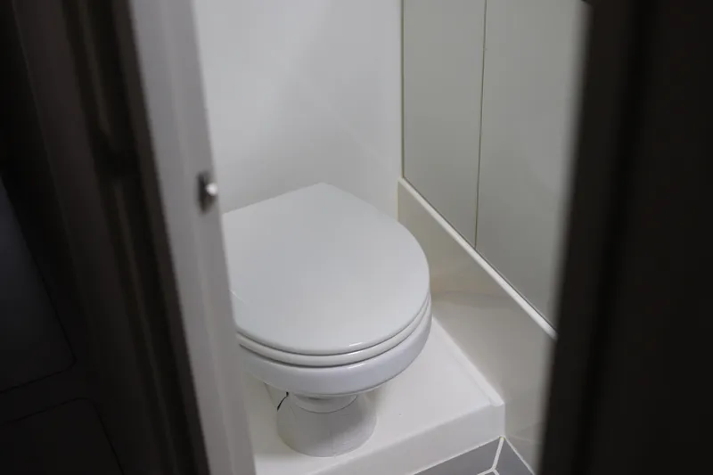 Why Knot Yacht Photos Pics Compact bathroom in 2020 Robertson Leopard model, featuring a modern white toilet.