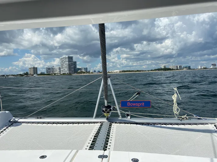 Why Knot Yacht Photos Pics Sailing on a 2020 Robertson Leopard catamaran with bowsprit, city skyline in background.