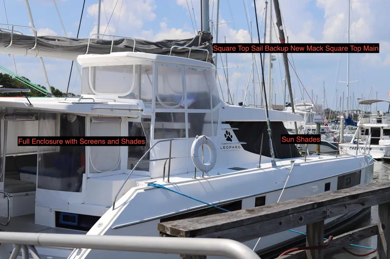 Why Knot Yacht Photos Pics 2020 Robertson Leopard catamaran with full enclosure, sun shades, and square top sail, docked at marina.