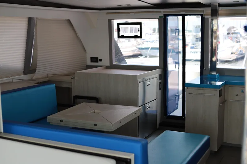 Why Knot Yacht Photos Pics Modern interior of a 2020 Robertson Leopard yacht with blue seating and sleek cabinetry.