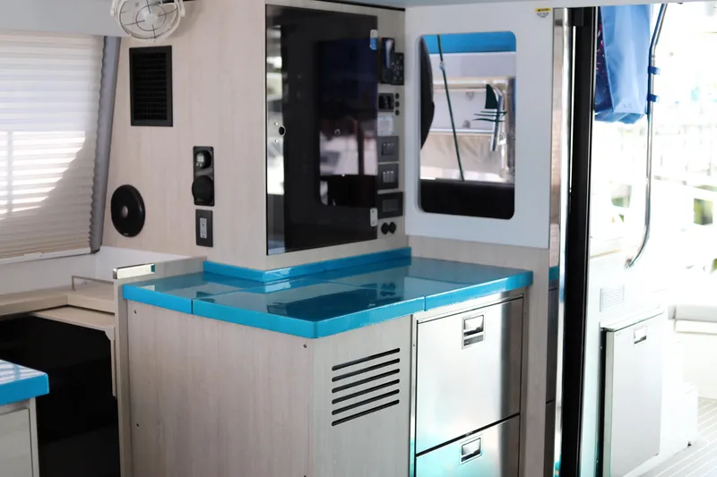 Why Knot Yacht Photos Pics Modern interior of a 2020 Robertson Leopard yacht with sleek cabinetry and blue countertops.