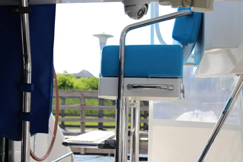 Why Knot Yacht Photos Pics Blue cushioned seat on 2020 Robertson Leopard boat, featuring stainless steel frame and outdoor setting.