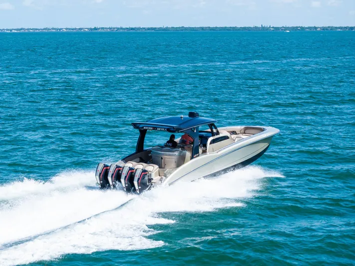  Yacht Photos Pics MTI V42 2021 speedboat cruising on open blue water with powerful engines.