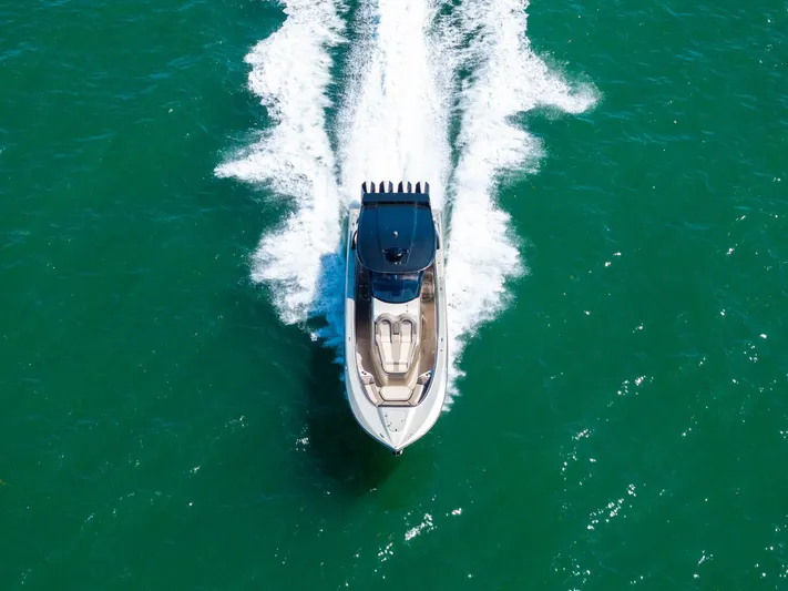  Yacht Photos Pics Aerial view of 2021 MTI V42 speedboat cruising on turquoise water.