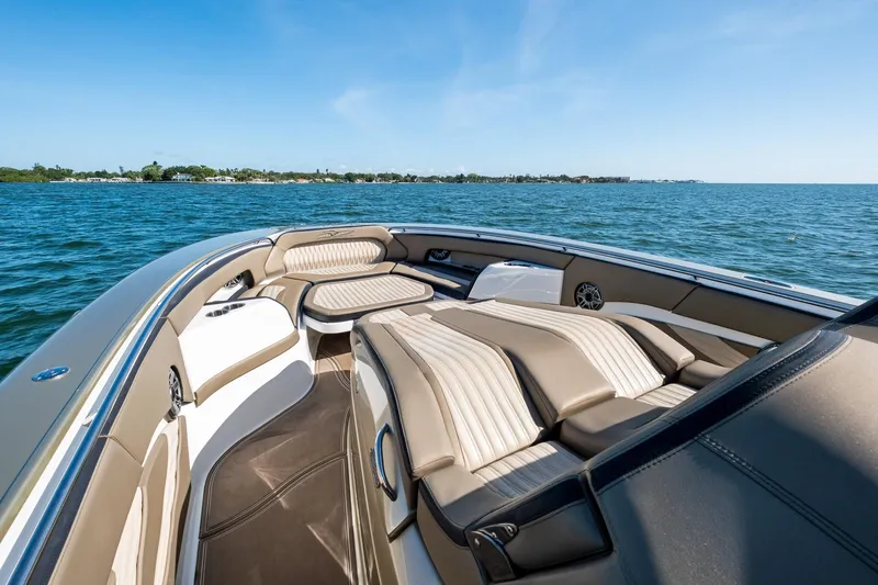  Yacht Photos Pics Luxury MTI V42 boat interior with plush seating, cruising on open water under clear blue skies.