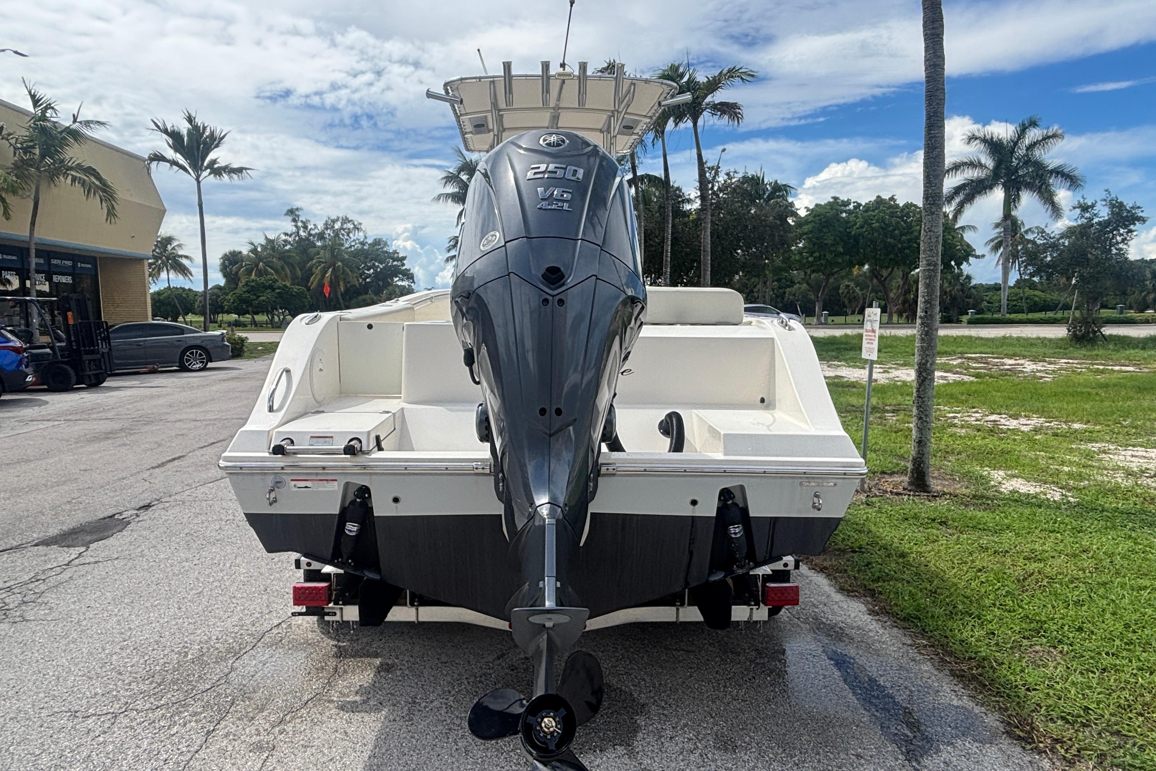 2022 Cobia 237 Center Console boat with powerful outboard motor, parked outdoors.