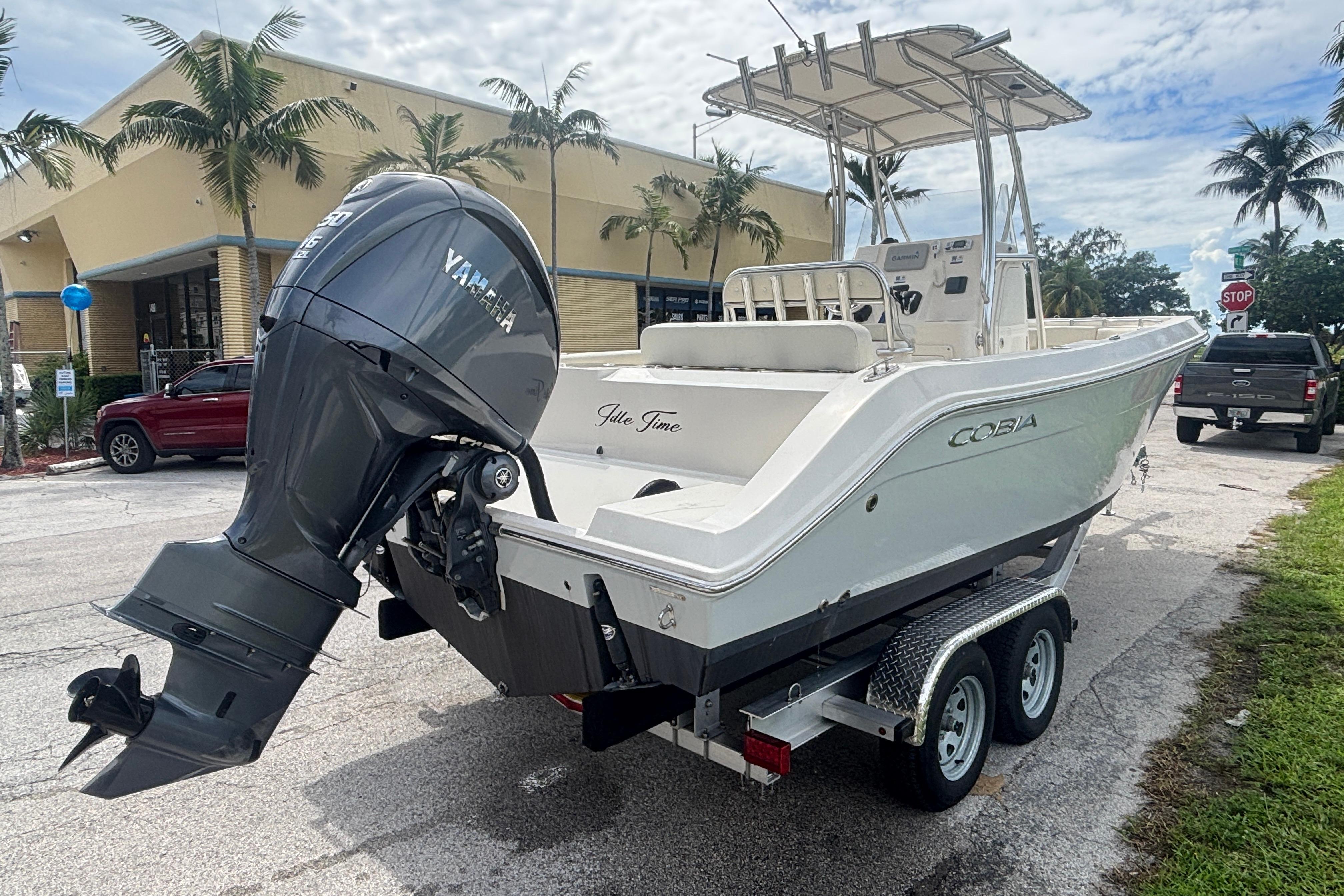 2022 Cobia 237 Center Console boat with Yamaha engine on trailer, parked outdoors.