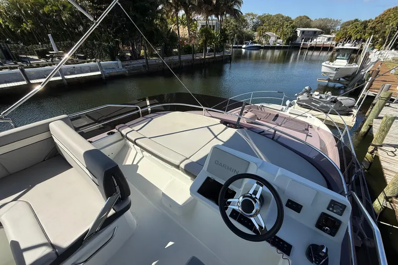 Yacht Photos Pics 2024 Jeanneau NC 1295 Fly yacht with sleek design, docked in a serene marina.