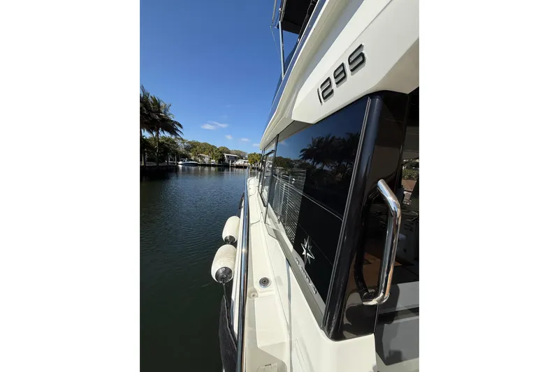  Yacht Photos Pics 2024 Jeanneau NC 1295 Fly yacht docked by a serene waterfront.
