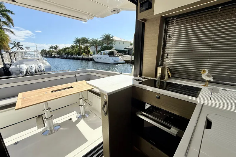  Yacht Photos Pics 2024 Jeanneau NC 1295 Fly yacht interior with kitchen and canal view.