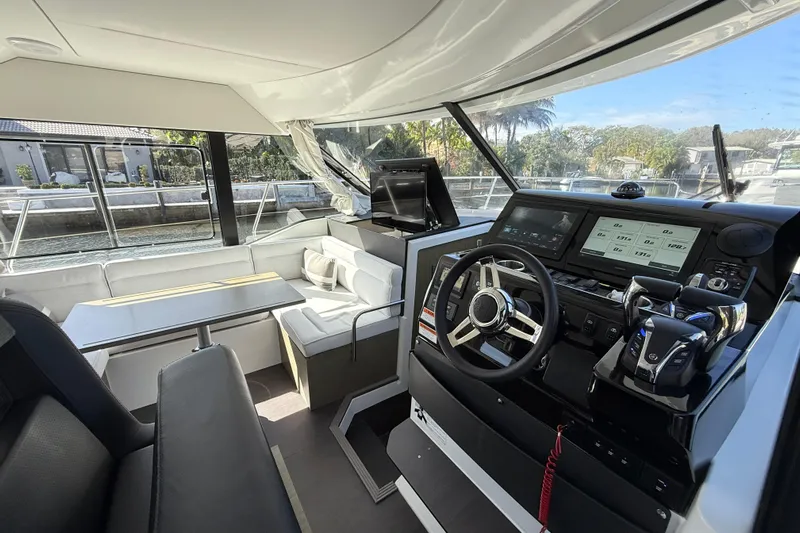  Yacht Photos Pics Interior of 2024 Jeanneau NC 1295 Fly yacht, featuring modern helm and seating area.