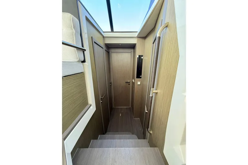 Yacht Photos Pics Interior of 2024 Jeanneau NC 1295 Fly, featuring modern wood paneling and sleek design.