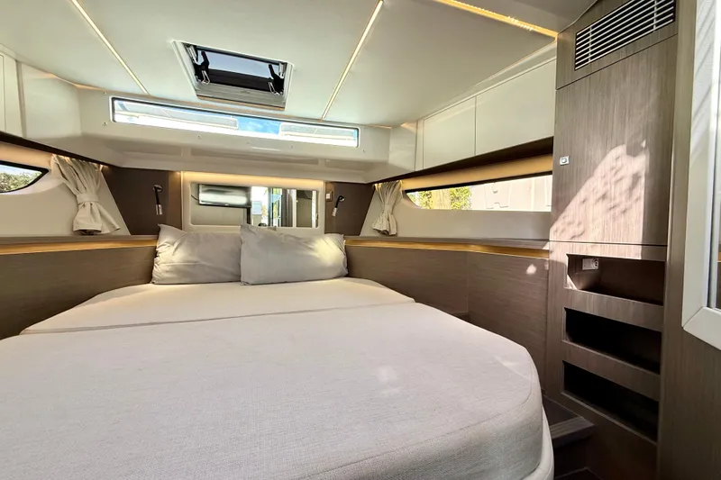  Yacht Photos Pics Luxurious cabin interior of 2024 Jeanneau NC 1295 Fly yacht, featuring a spacious bed.