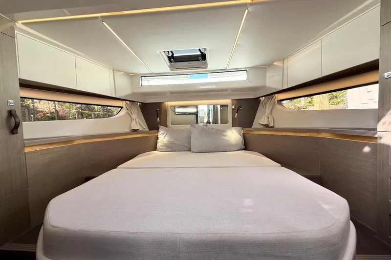  Yacht Photos Pics Luxurious interior cabin of 2024 Jeanneau NC 1295 Fly yacht, featuring a spacious bed.