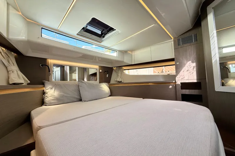  Yacht Photos Pics Luxurious interior cabin of 2024 Jeanneau NC 1295 Fly yacht, featuring modern design and comfortable bedding.