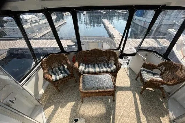  Yacht Photos Pics 1999 Carver 404 Cockpit Motor Yacht interior with wicker seating and marina view.
