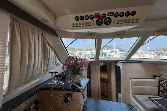  Yacht Photos Pics 1999 Carver 404 Cockpit Motor Yacht interior with helm, seating, and floral decor.