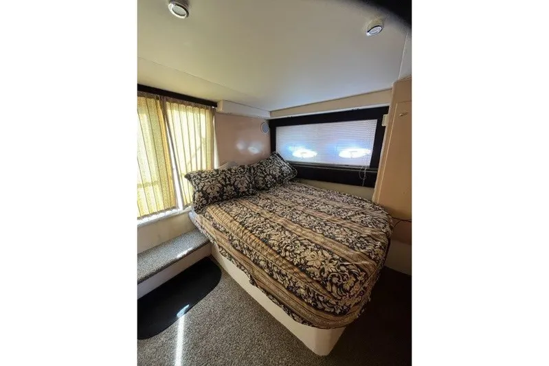 Yacht Photos Pics Cozy bedroom interior of 1999 Carver 404 Cockpit Motor Yacht with patterned bedding.
