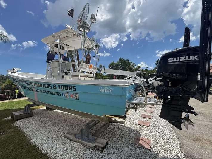  Yacht Photos Pics 2007 Andros Tarpon 26 boat on display with Suzuki outboard motor, under a clear blue sky.