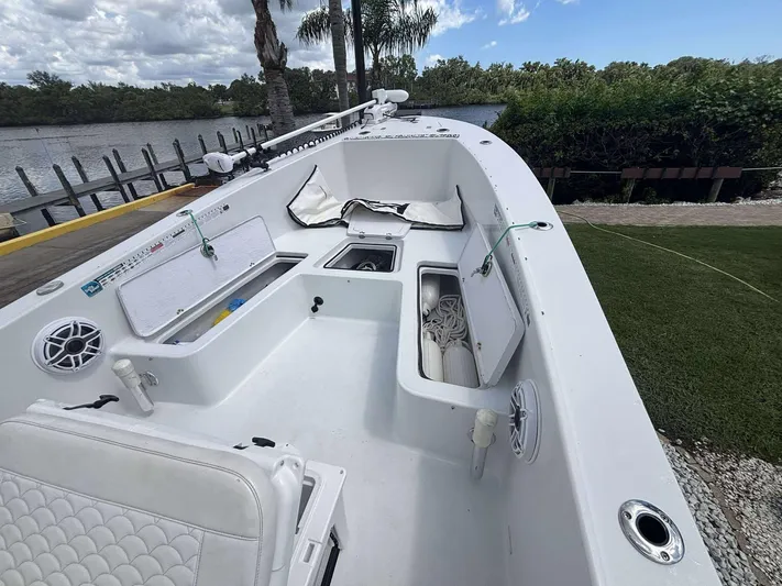  Yacht Photos Pics 2007 Andros Tarpon 26 boat interior with storage compartments and seating, docked by a scenic river.