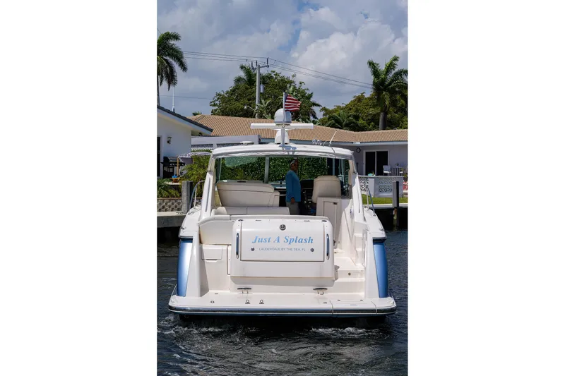  Yacht Photos Pics 2013 Tiara Yachts 3900 Sovran, rear view, docked near palm trees and houses.