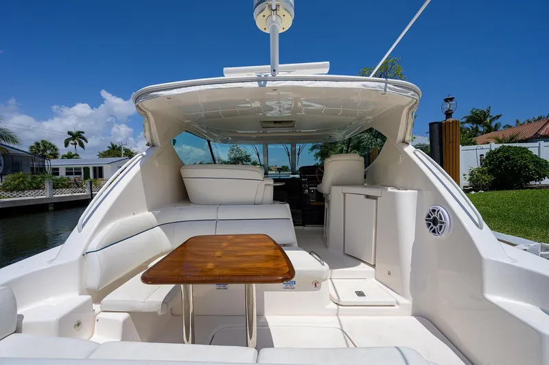  Yacht Photos Pics 2013 Tiara Yachts 3900 Sovran with elegant seating and wooden table, docked by a canal.