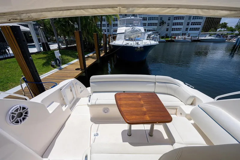  Yacht Photos Pics 2013 Tiara Yachts 3900 Sovran cockpit with wooden table, docked at marina.