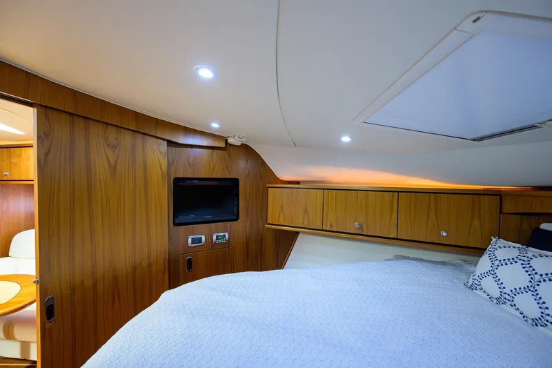  Yacht Photos Pics Luxurious interior of 2013 Tiara Yachts 3900 Sovran with wood paneling and cozy bedding.