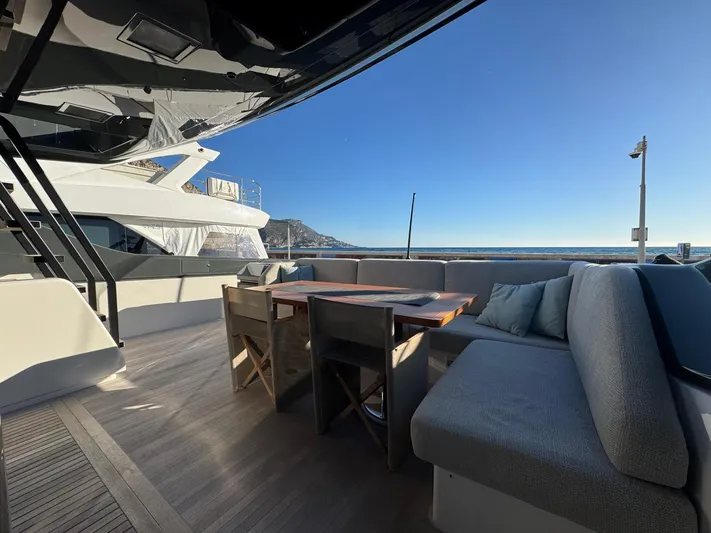  Yacht Photos Pics Luxurious 2022 Bluegame BGX70 yacht deck with seating, table, and ocean view.