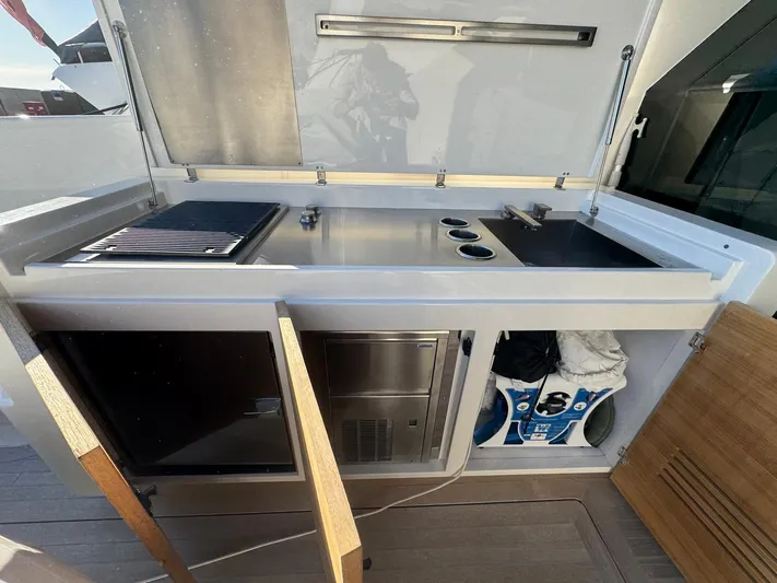  Yacht Photos Pics Outdoor kitchen on 2022 Bluegame BGX70 yacht with grill and storage compartments.