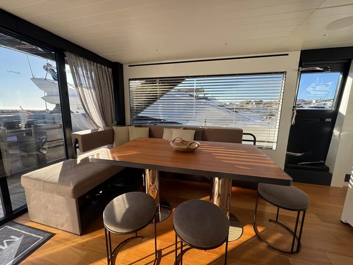  Yacht Photos Pics Luxurious interior of 2022 Bluegame BGX70 yacht with modern dining area and panoramic windows.