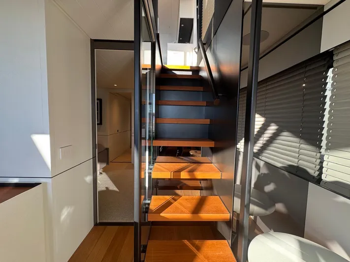  Yacht Photos Pics Interior of 2022 Bluegame BGX70 yacht featuring modern wooden staircase and sleek design.