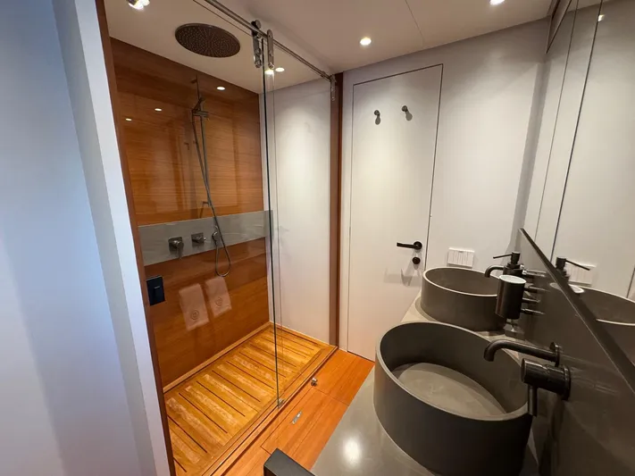  Yacht Photos Pics Luxurious bathroom in 2022 Bluegame BGX70 yacht with dual sinks and modern shower.