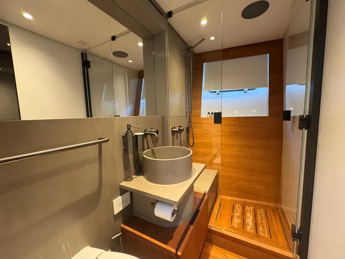 Yacht Photos Pics Luxurious bathroom in 2022 Bluegame BGX70 yacht with modern fixtures and wooden accents.