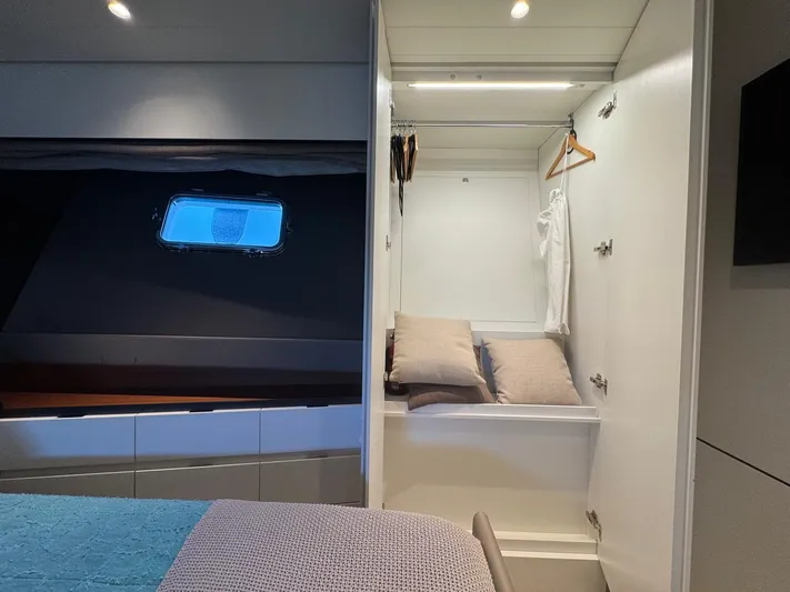  Yacht Photos Pics Luxurious interior of 2022 Bluegame BGX70 yacht with closet and bedding.