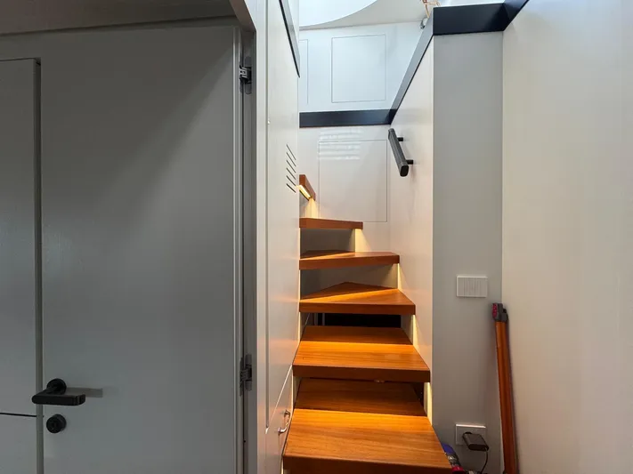  Yacht Photos Pics Staircase inside 2022 Bluegame BGX70 yacht with wooden steps and modern design.
