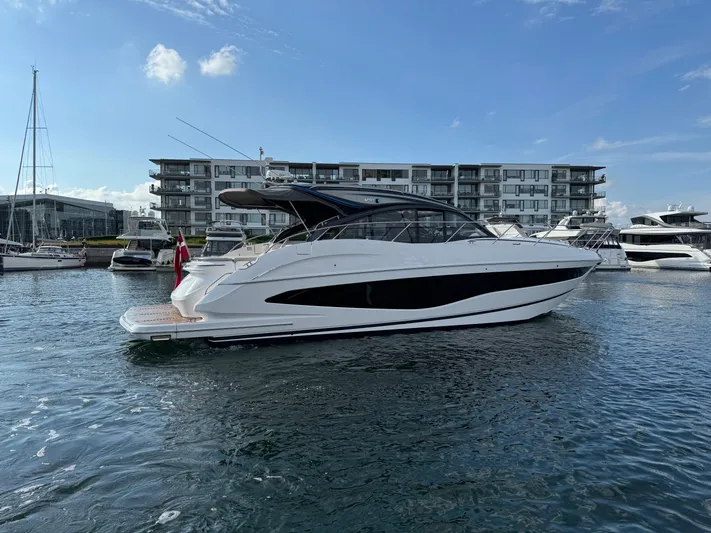  Yacht Photos Pics 2023 Princess V50 Open yacht docked in a marina, with modern buildings in the background.