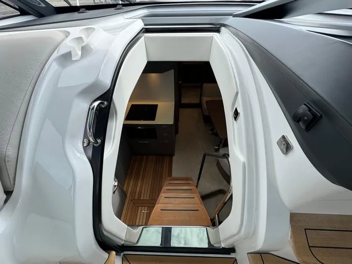  Yacht Photos Pics 2023 Princess V50 Open yacht interior with modern kitchen and wooden flooring.