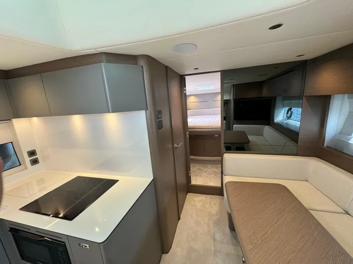  Yacht Photos Pics Luxurious interior of 2023 Princess V50 Open yacht with modern kitchen and seating area.
