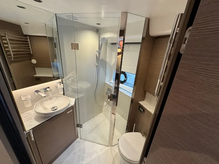  Yacht Photos Pics Luxurious bathroom in 2023 Princess V50 Open yacht with modern fixtures and glass shower.