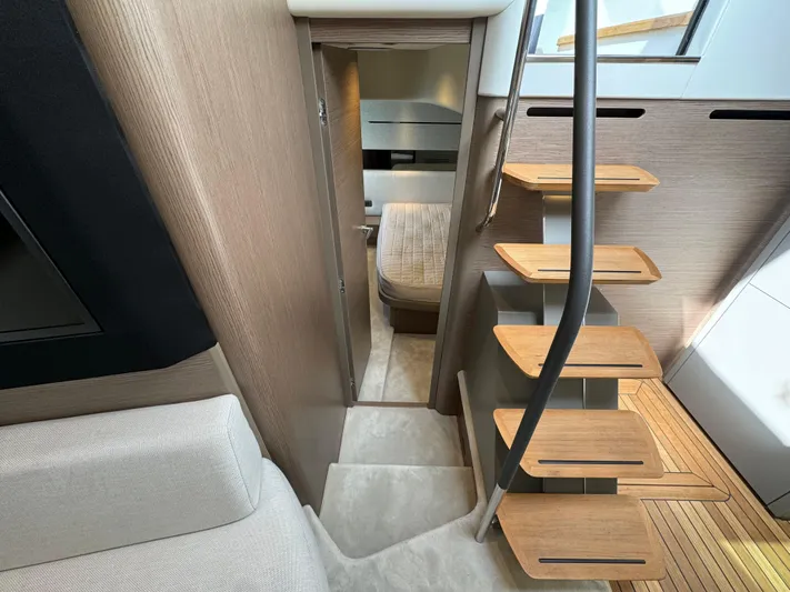  Yacht Photos Pics Modern interior of 2023 Princess V50 Open yacht with wooden stairs and cozy cabin.