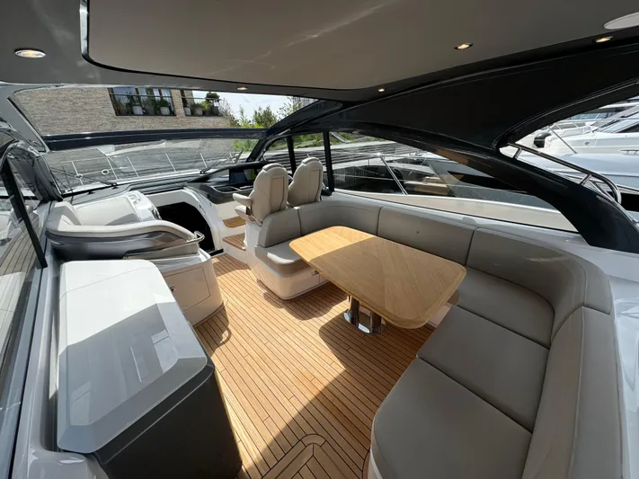  Yacht Photos Pics 2023 Princess V50 Open yacht interior with sleek seating and wooden table.