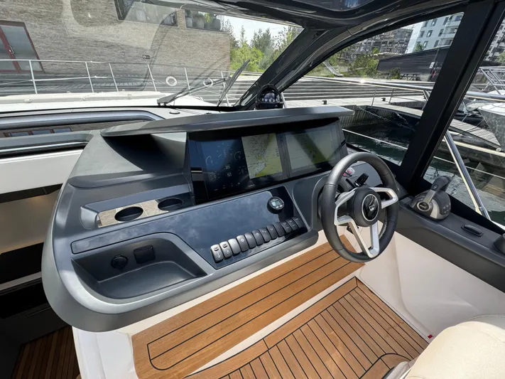  Yacht Photos Pics Helm of 2023 Princess V50 Open yacht with modern controls and wooden flooring.