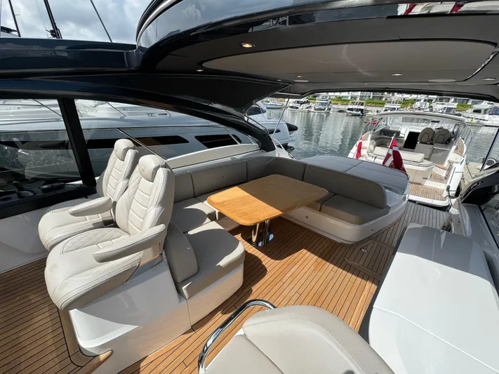  Yacht Photos Pics Luxurious 2023 Princess V50 Open yacht interior with elegant seating and wooden deck.