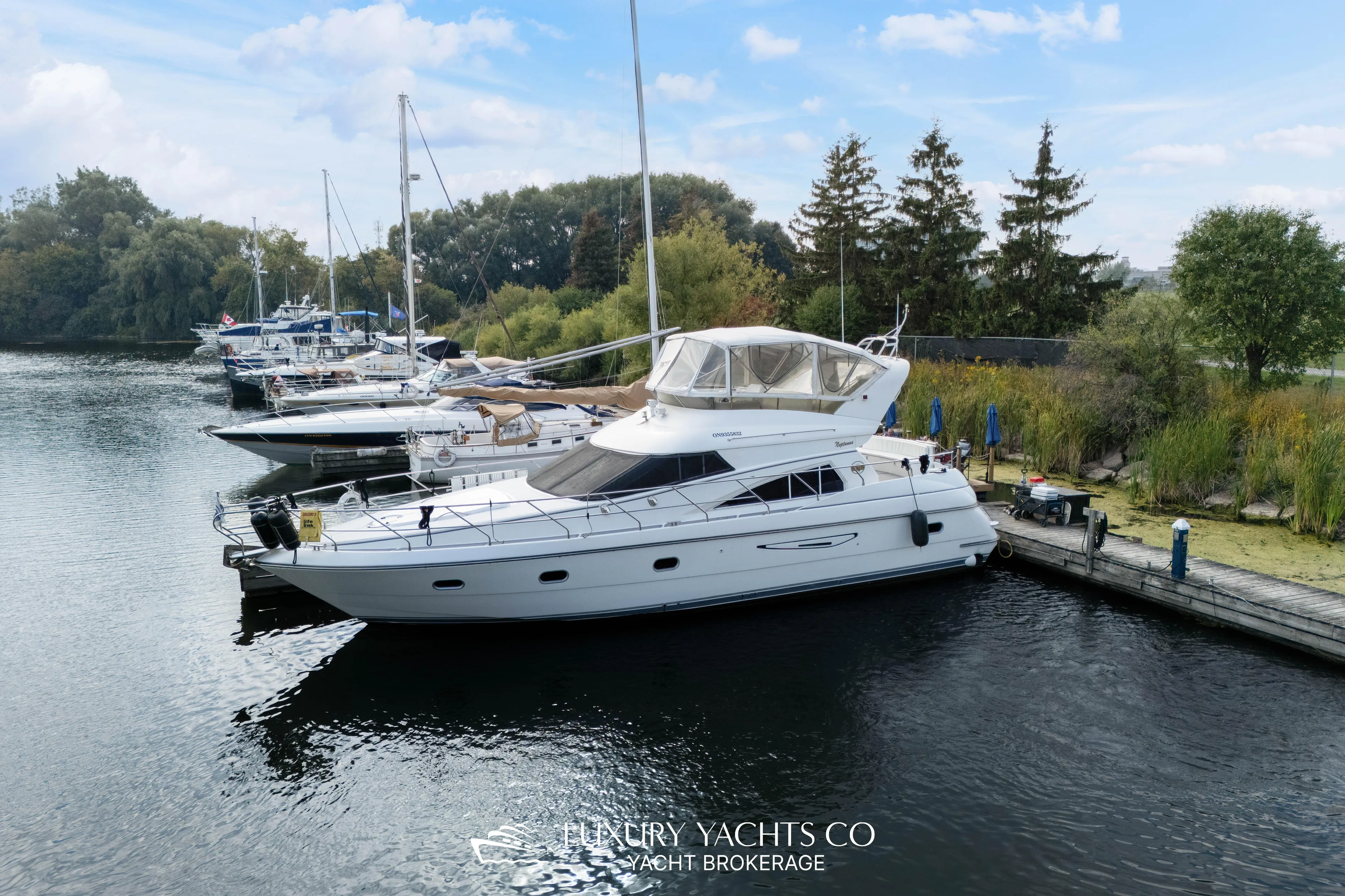  Yacht Photos Pics 1997 Neptunus 50 Aft Cabin yacht docked in a serene marina setting.