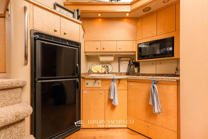  Yacht Photos Pics 1997 Neptunus 50 Aft Cabin yacht kitchen with modern appliances and wood cabinetry.