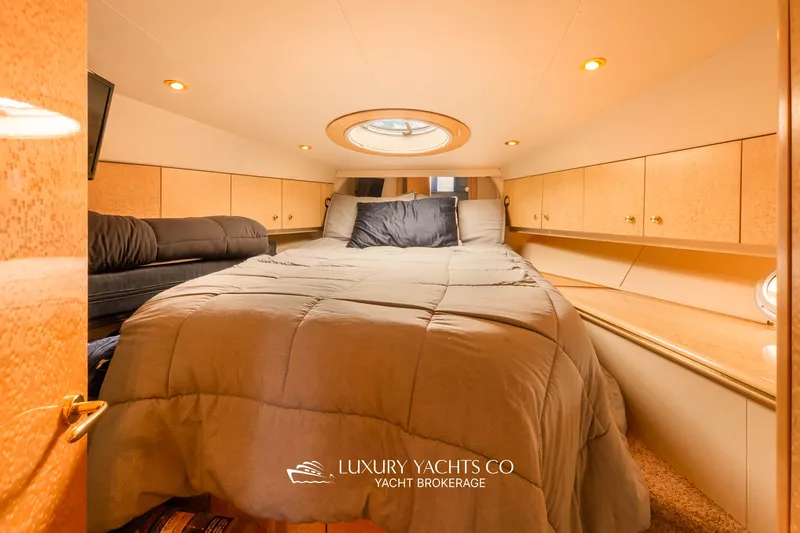  Yacht Photos Pics Luxurious 1997 Neptunus 50 Aft Cabin bedroom with cozy bedding and elegant wood finishes.
