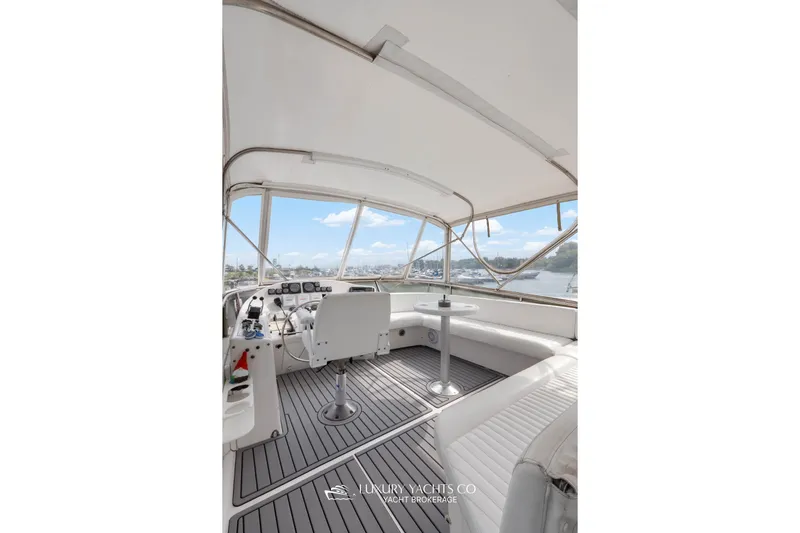  Yacht Photos Pics 1997 Neptunus 50 Aft Cabin yacht interior with helm, seating, and panoramic windows.